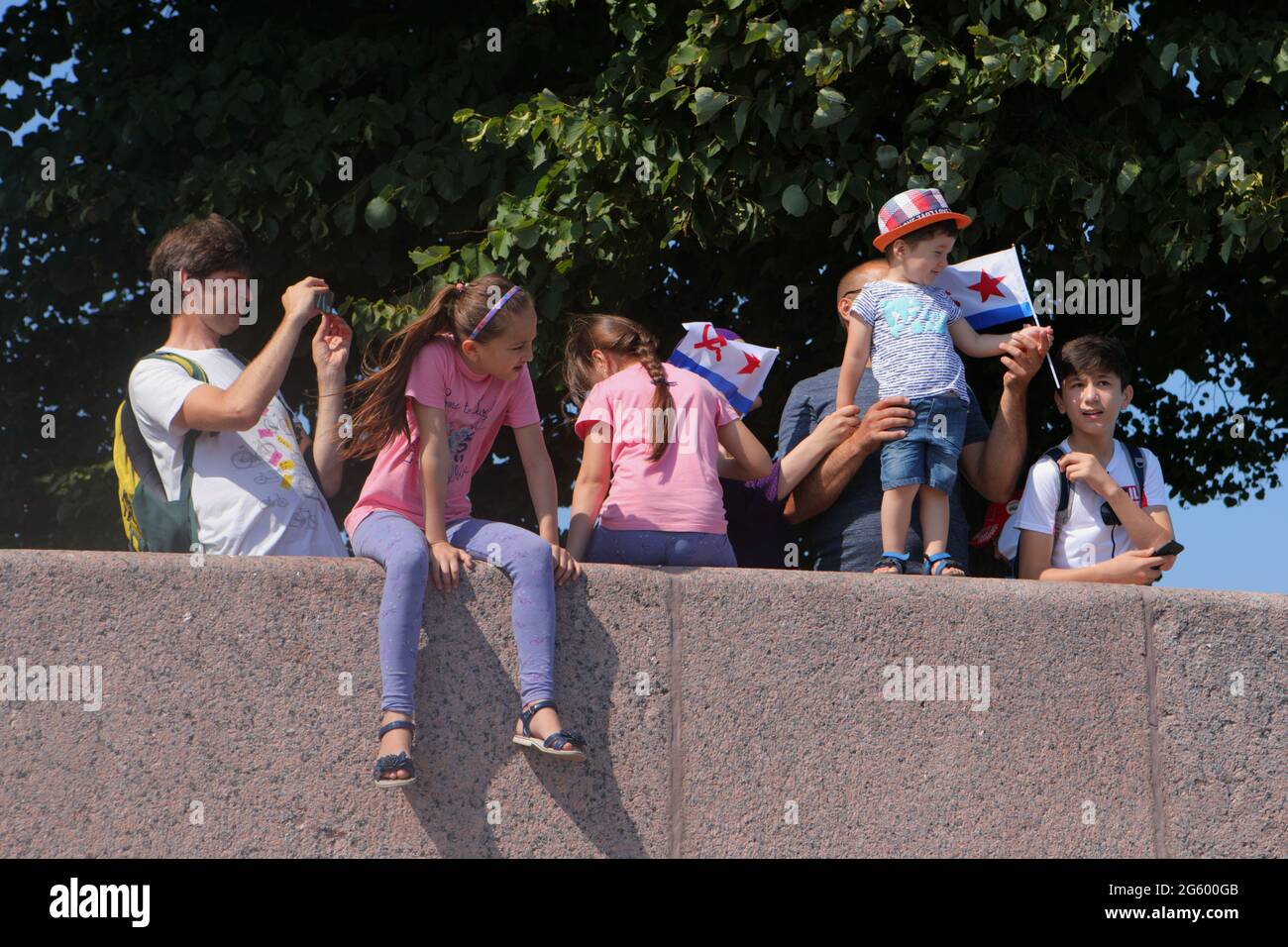 St. Petersburg, Russia, 29th July, 2018: Family with children holding small flags of Russian Navy make photo in the city during celebration of Russian Navy day. Russian Navy day is celebrated last Sunday of July Stock Photo