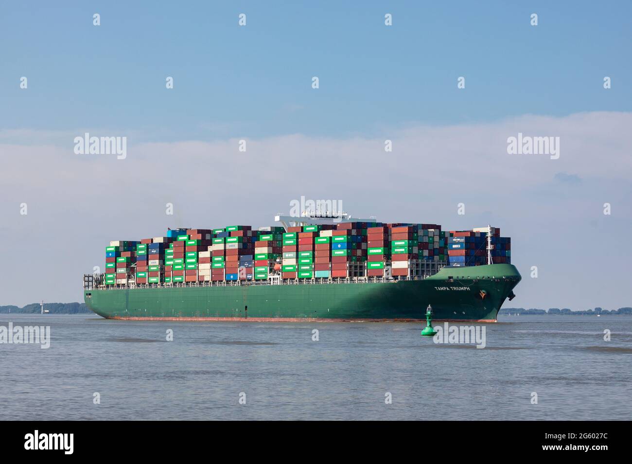 Stade, Germany - June 25, 2021: Container ship TAMPA TRIUMPH, owned by Costamare and operated by Evergreen Marine, on Elbe river heading to Hamburg Stock Photo