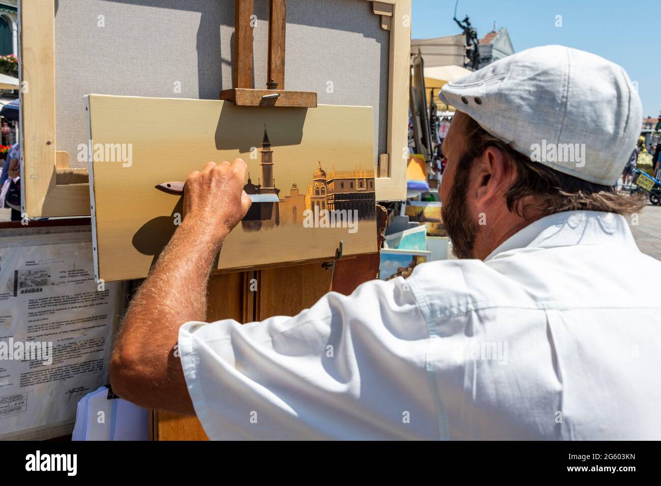 An artist using acrylic paint with a pallet knife, painting a local scene near the Venetian Lagoon in Venice, northern Italy. Stock Photo