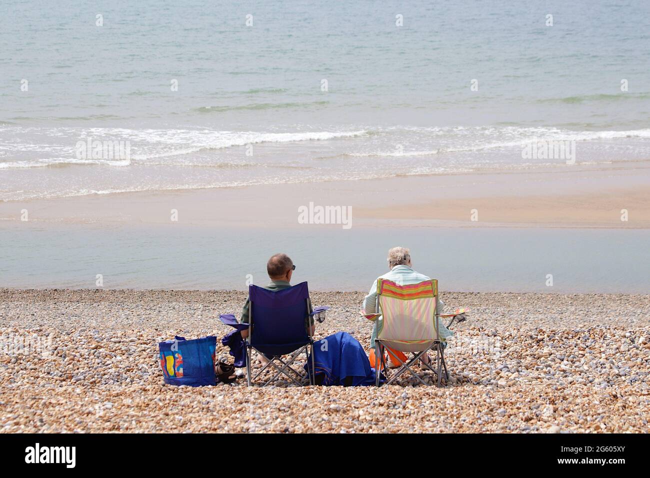 Couple sitting in deckchairs on the beach hi-res stock photography and ...