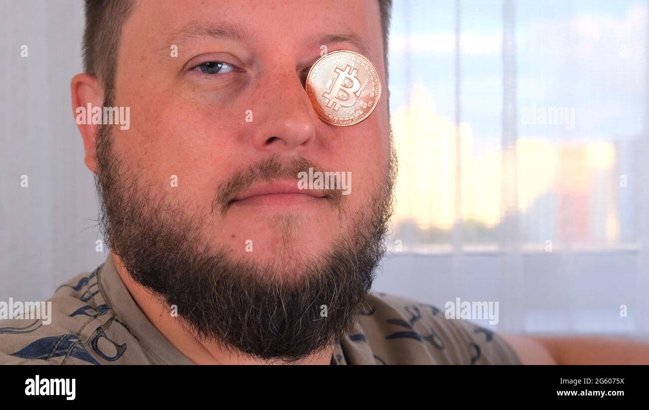 man holds bitcoins. Male with bitcoin in eye. Bitcoin is a cryptocurrency  invented in 2008 by an unknown person or group of people using the name  Stock Photo - Alamy