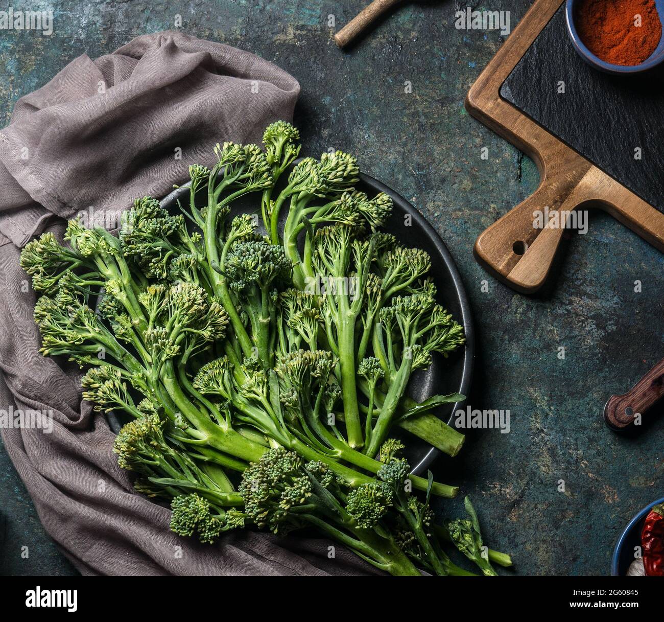 Bunch of wild broccoli on a dark kitchen table for healthy cooking and vegan cuisine. View from above Stock Photo