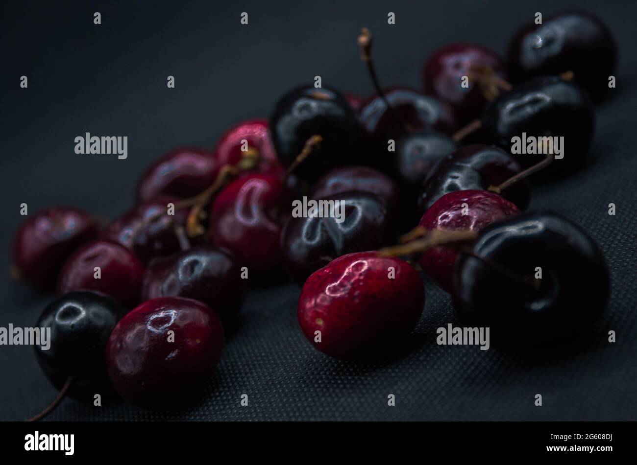 Cherries with water drops on a black table. Ripe cherries. Sweet red cherry. top view. Rustic style. fruit wallpaper Stock Photo