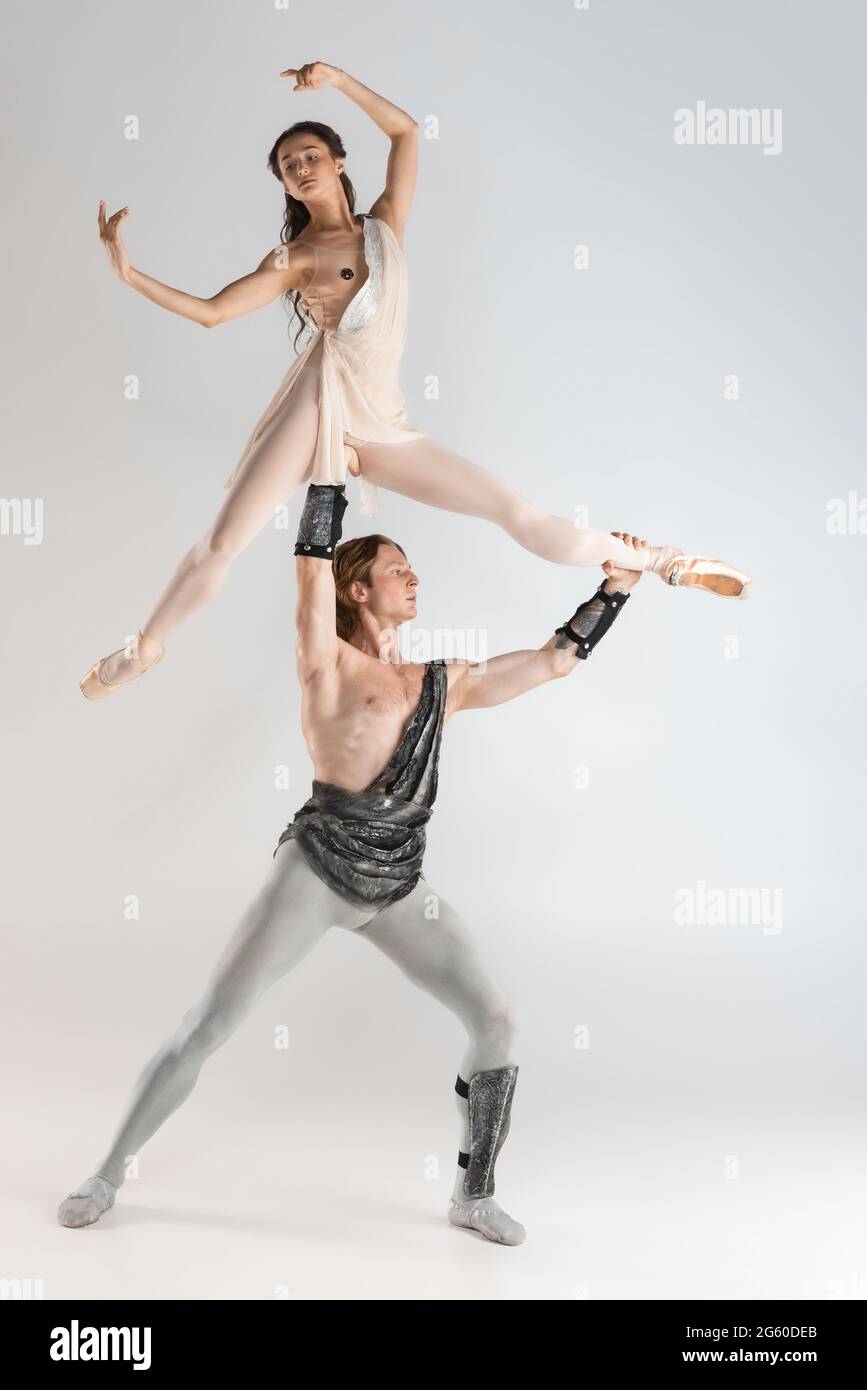 Young couple of ballet dancers in ancient Rome costumes dancing on