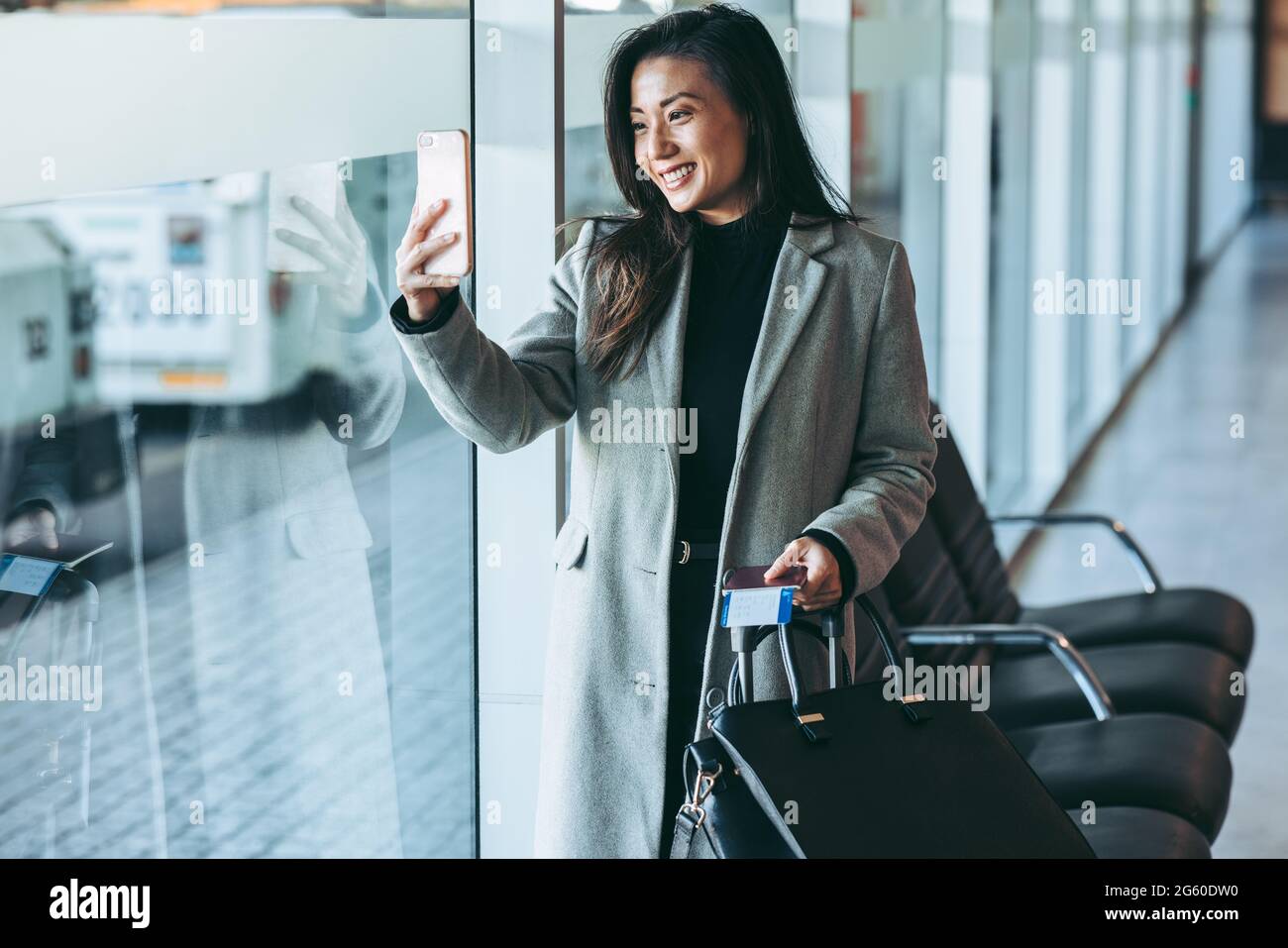 Woman traveler at airport terminal taking selfie. Woman passenger at ...