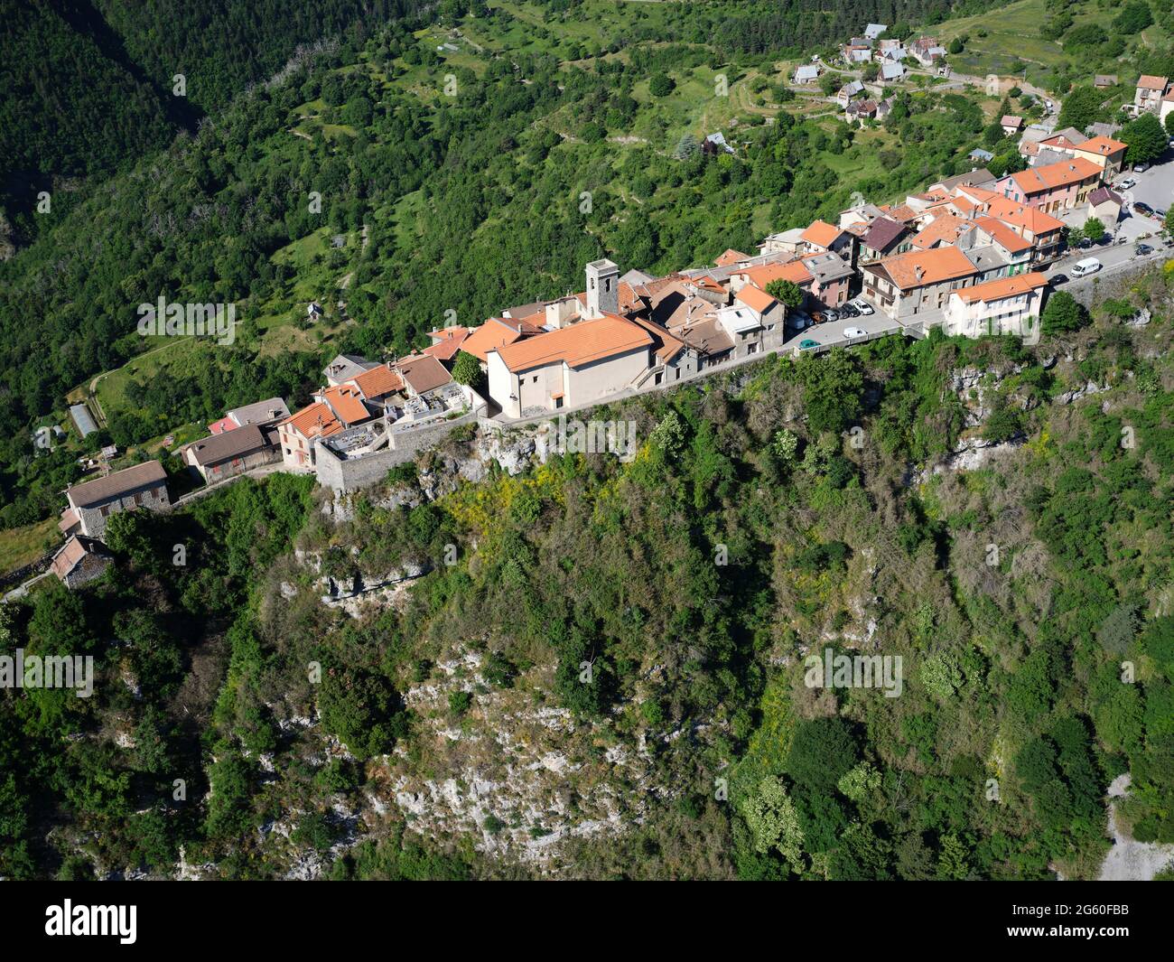 AERIAL VIEW. Medieval village perched on a long and narrow limestone ridge high above the Vésubie Valley. Alpes-Maritimes, France. Stock Photo