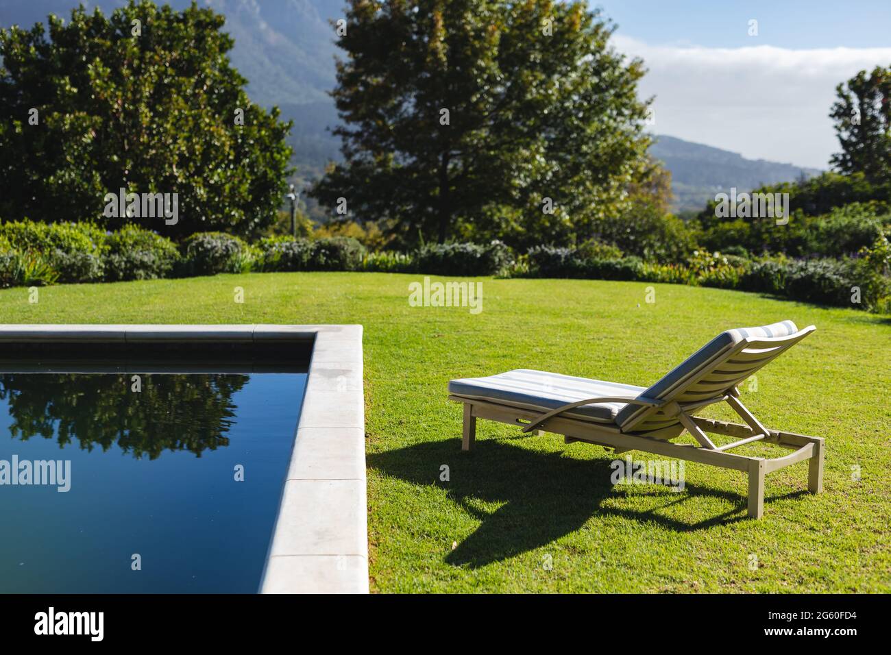 General view of tranquil swimming pool and deckchair with stunning ...
