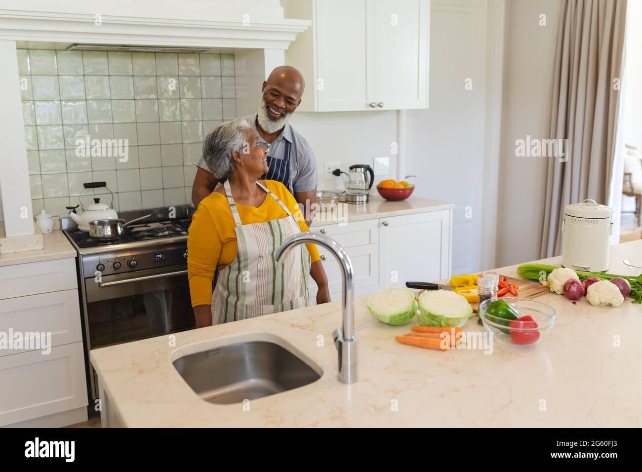 Senior african american couple cooking together in kitchen smiling ...