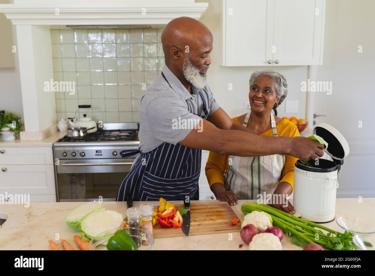 Senior african american couple cooking together in kitchen smiling ...