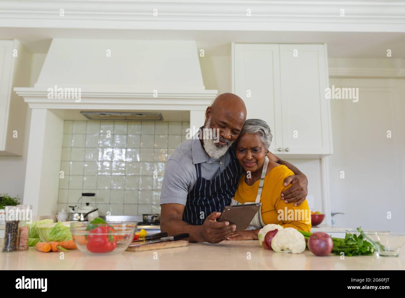 Senior african american couple cooking together in kitchen using tablet ...