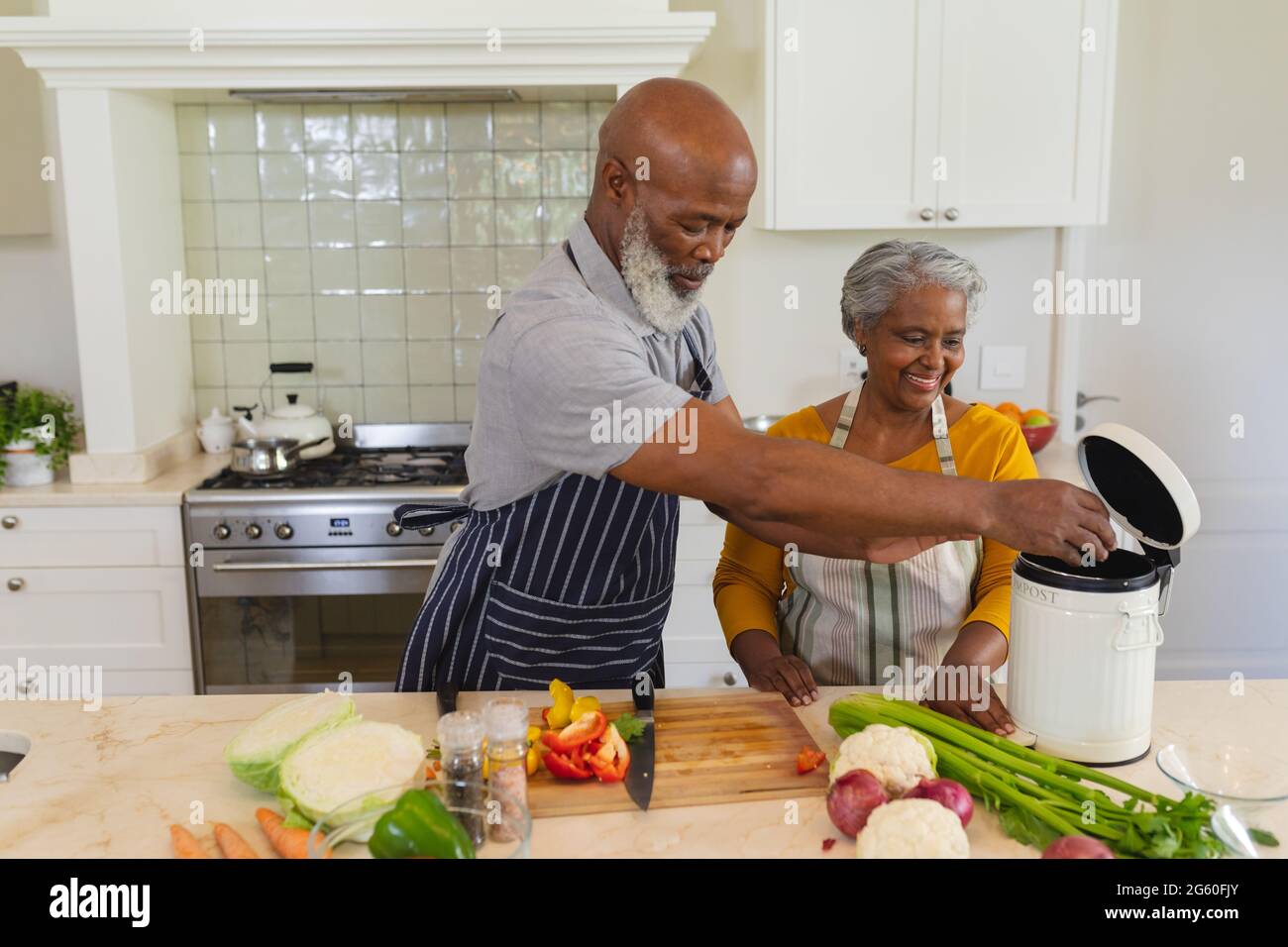 Senior african american couple cooking together in kitchen smiling ...
