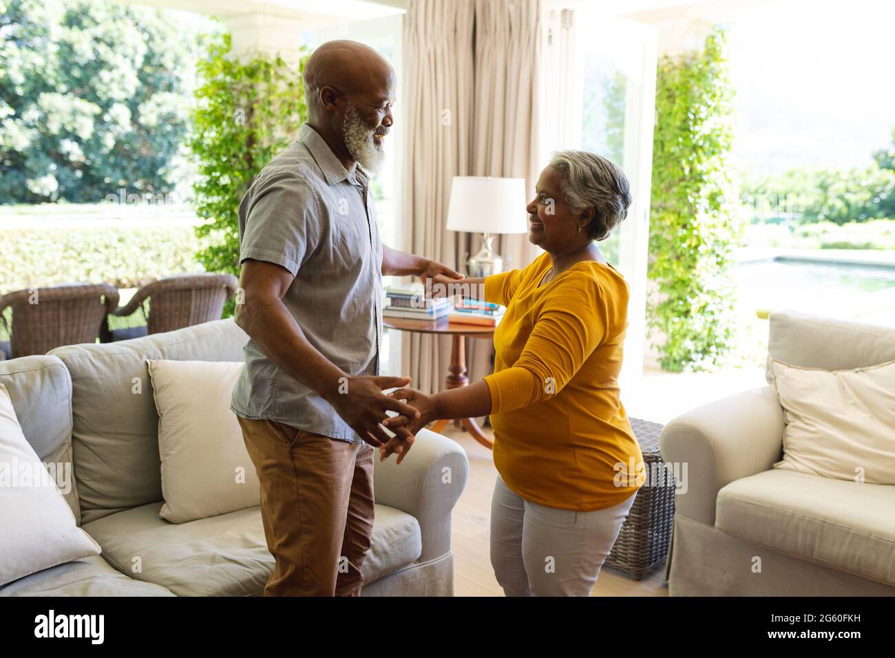 Senior african american couple dancing together in living room smiling ...