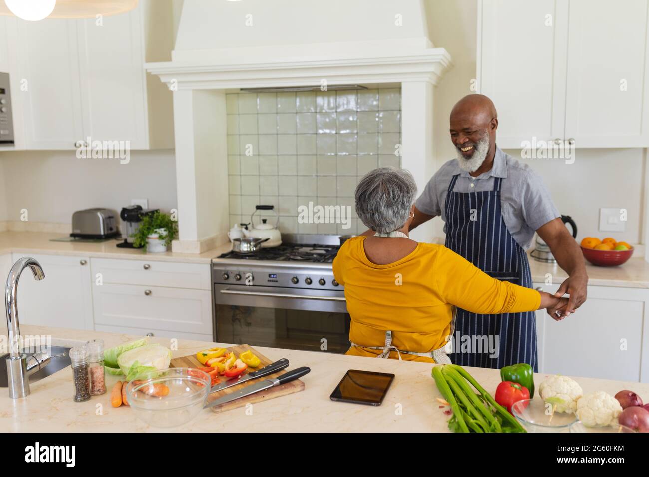 Senior african american couple dancing together in kitchen smiling ...