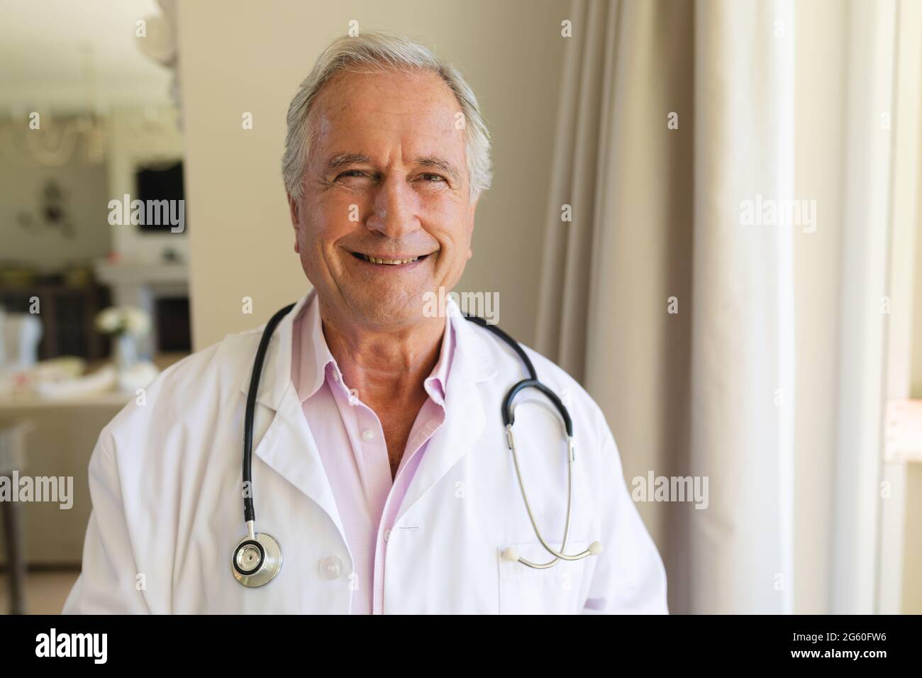Portrait of senior caucasian male doctor looking at camera and smiling ...