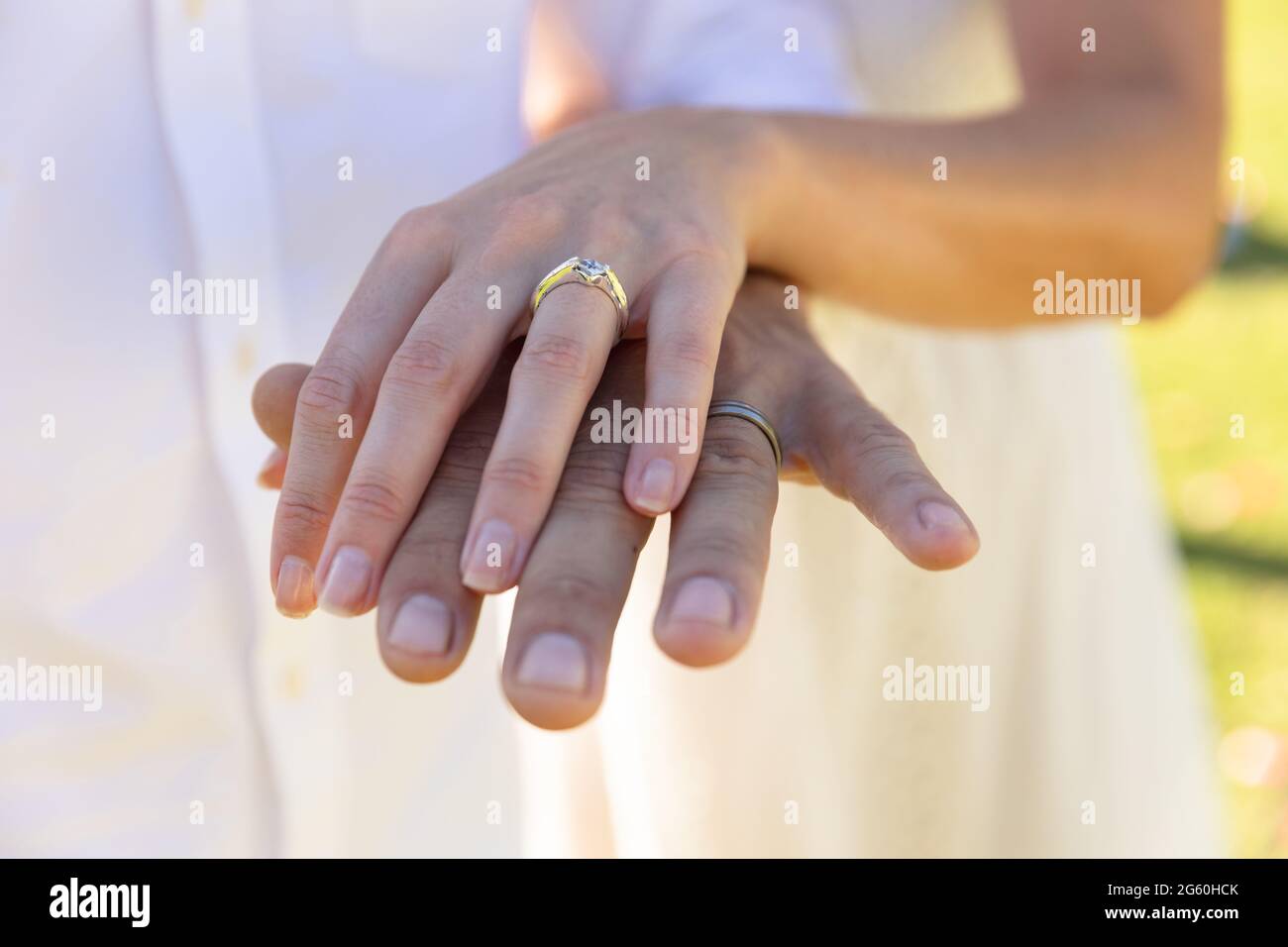 Caucasian bride and groom getting married and wearing rings Stock Photo