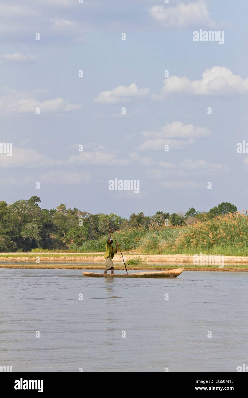 A local man rows down the Rufiji River in a dugout canoe. Stock Photo