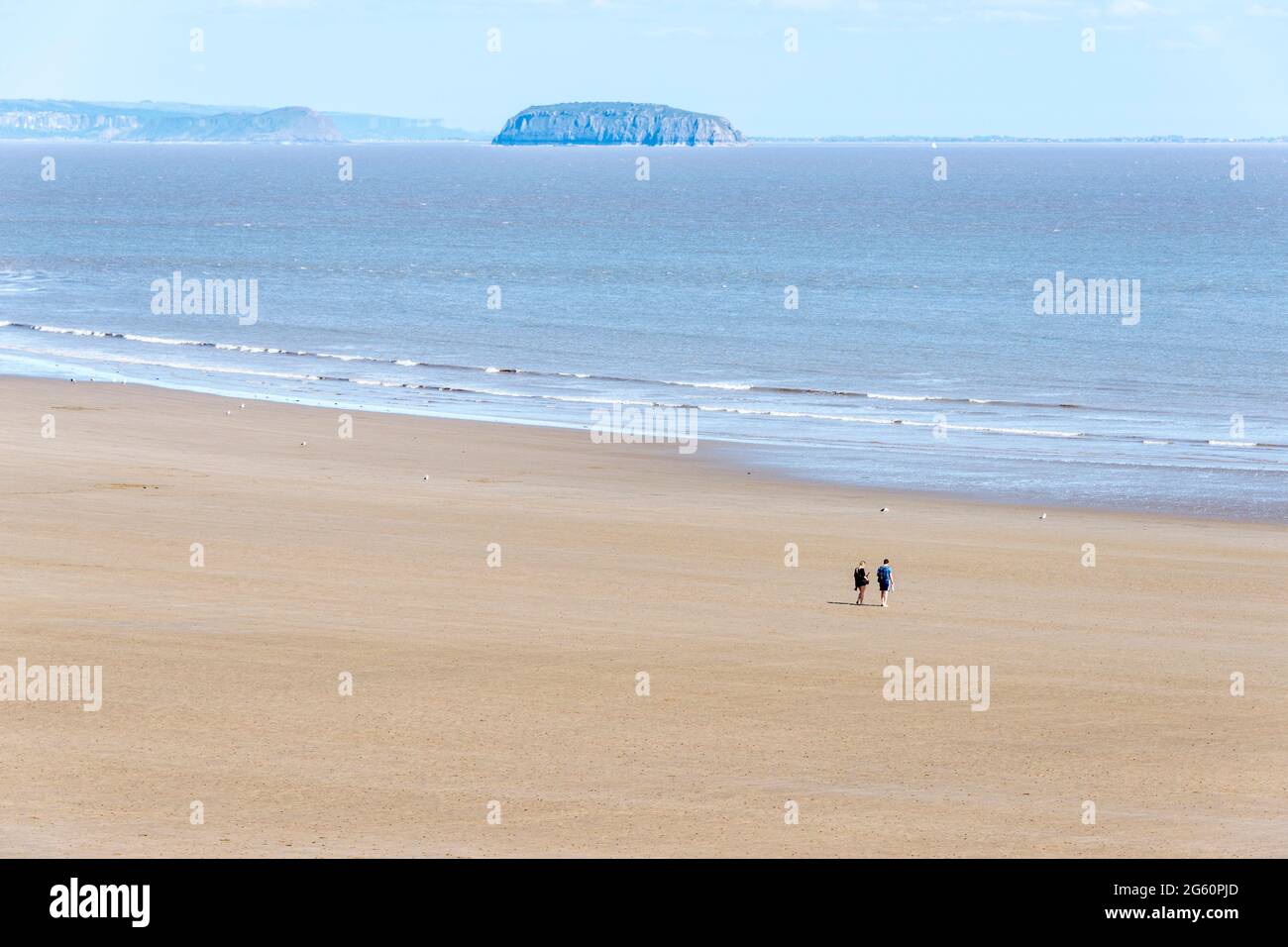 Due to the Covid-19 lockdown restrictions a couple have the beach at Barry Island to themselves despite it being a sunny spring bank holiday Stock Photo