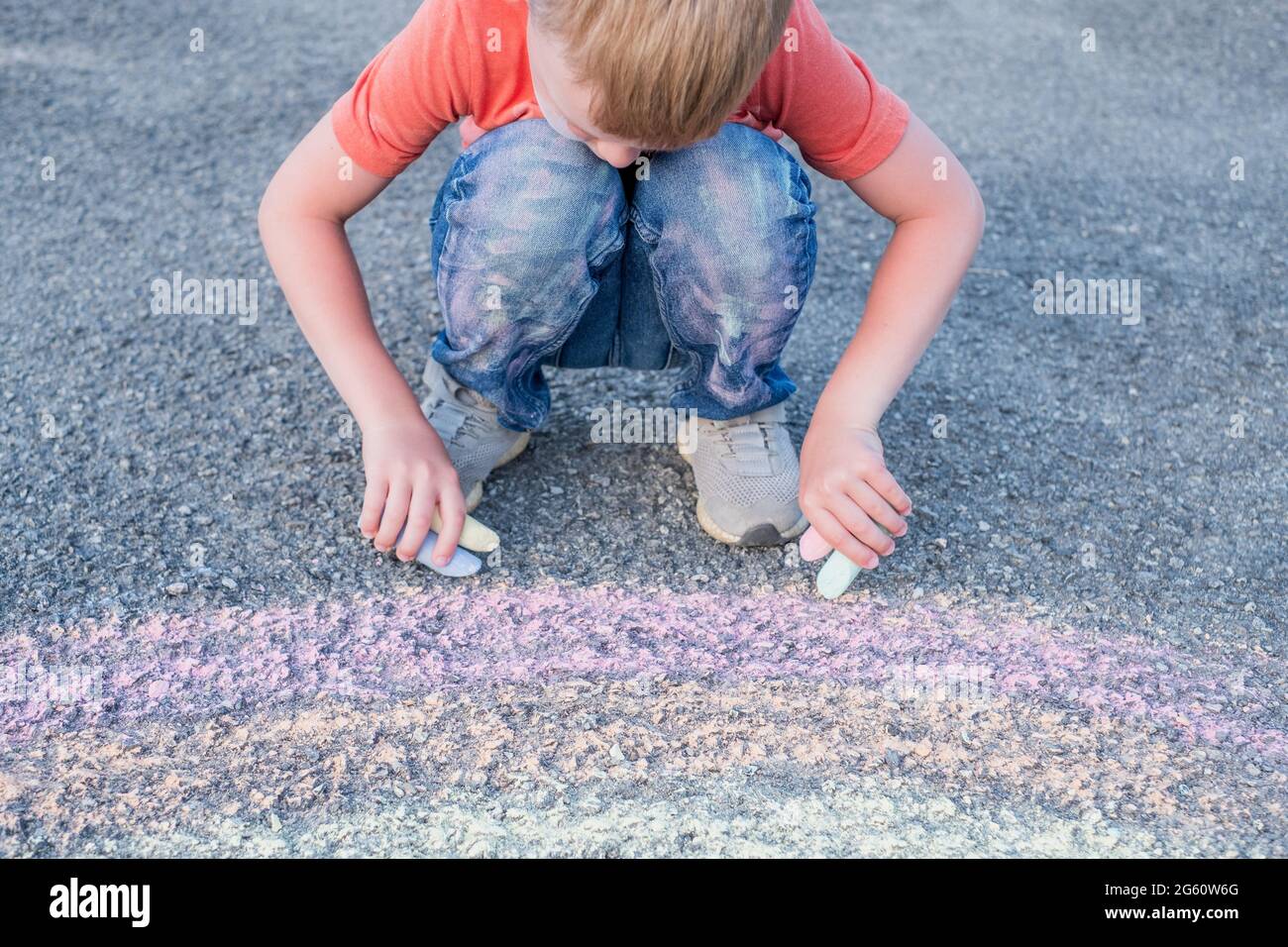 Cute boy drawing with chalk on the pavement. High quality photo Stock Photo
