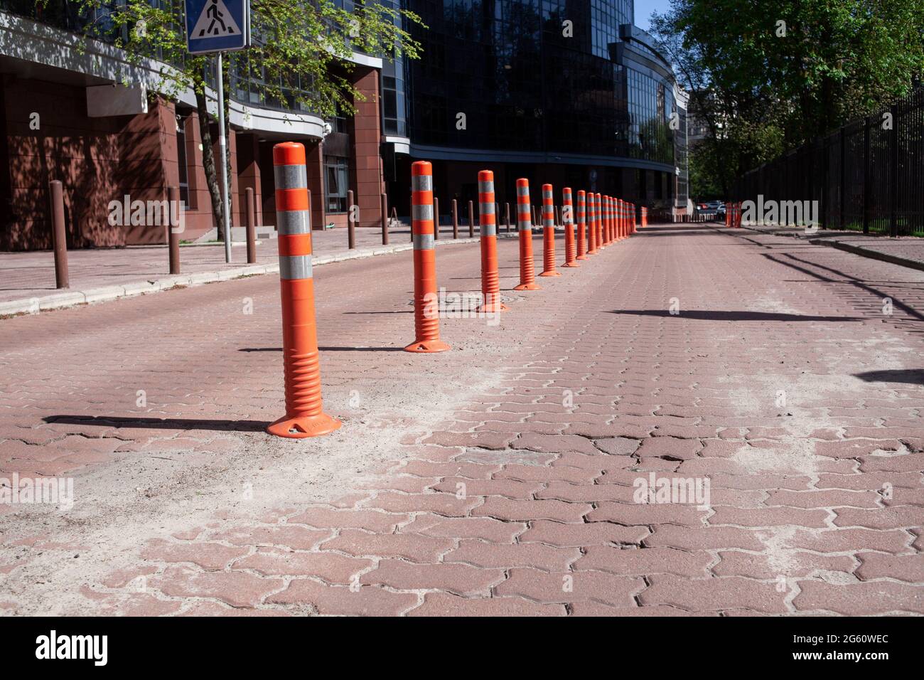 Orange bollard with reflective paint strips on the road. Traffic jam