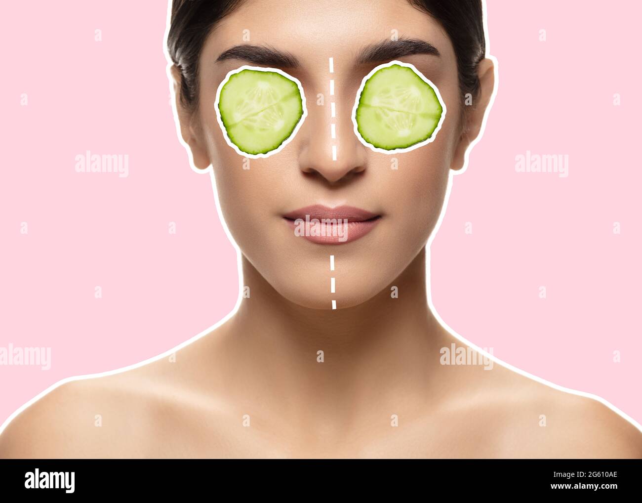 Portrait of a young beautiful woman holding cucumber slices on her eyes. Stock Photo