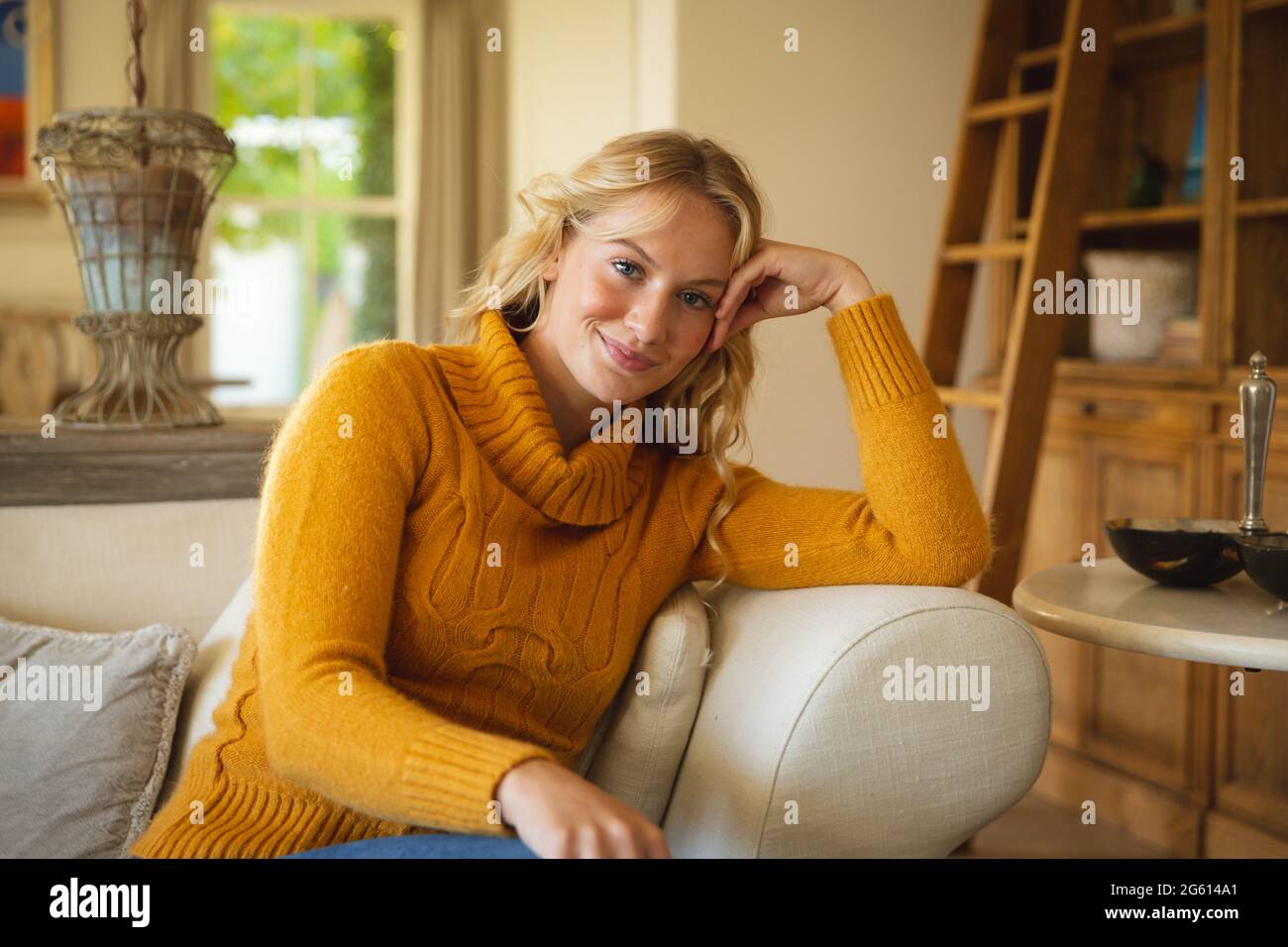 Portrait of happy caucasian woman sitting on couch in luxury living ...
