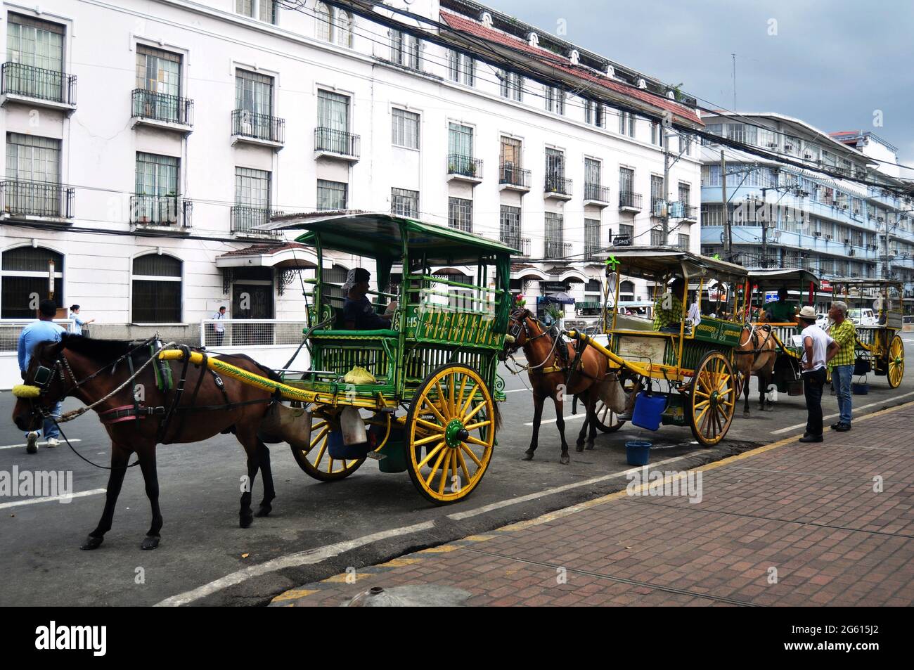 Filipino sit ride horse drawn carriages and waiting for Philippine people and foreign travelers use service travel visit tour Intramuros Square at May Stock Photo