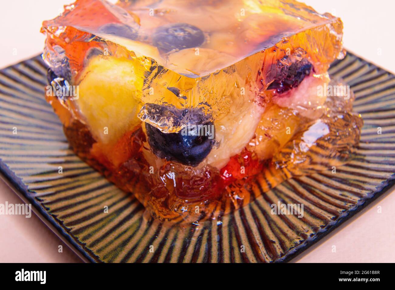 Jelly from different fruits and berries on a square saucer. Dessert. Close-up Stock Photo