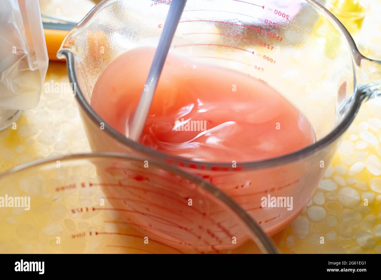 glass beaker filled with pink oil and lye solution saponification for