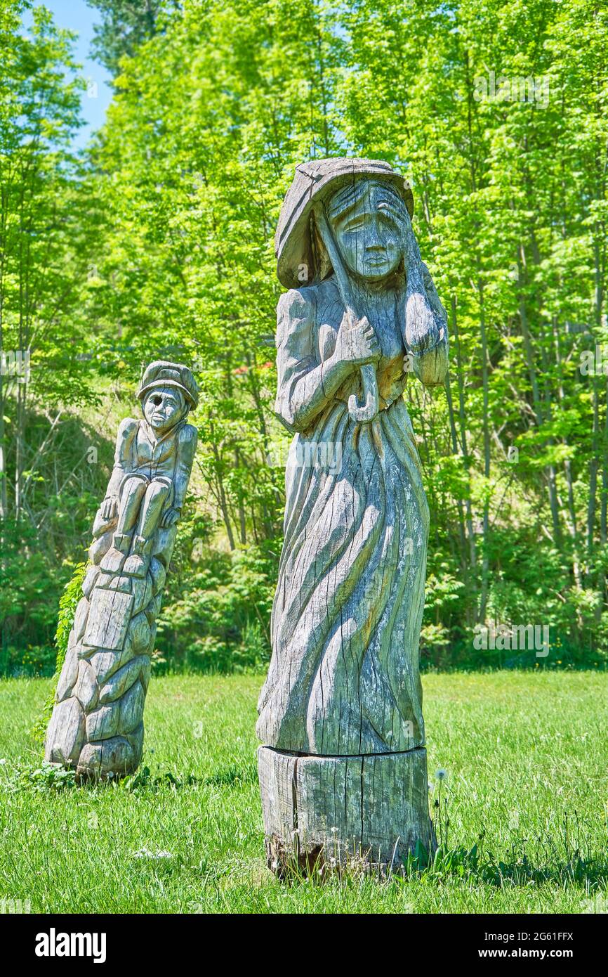 Wooden statues in a park area in Wiarton intricately carved using a chainsaw. This was a way to beautify old dead trees in the park. Stock Photo