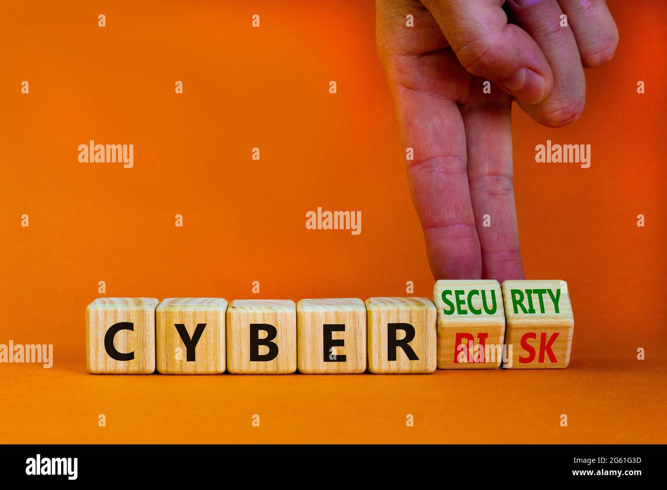 Cyber-security vs cyber-risk symbol. Businessman turns wooden cubes ...