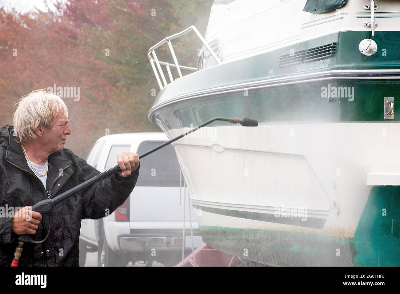 Caucasian man power washing boat Stock Photo Alamy