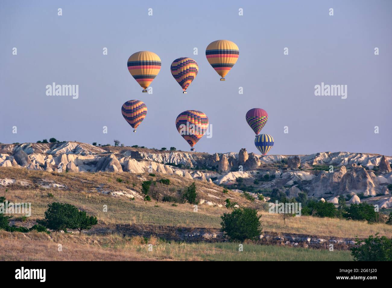 hot air balloons in the sky of Turkey flying over landscape of rock  formation in Goreme, landmark of tourism in Cappadocia Stock Photo - Alamy