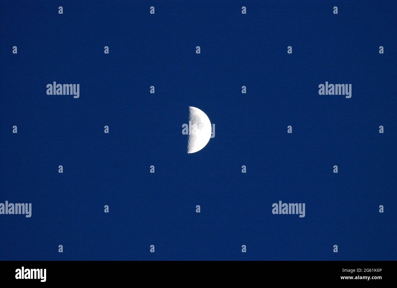 Brooklyn, NY, USA. 1st July, 2021. A First Quarter Moon, as seen from New York.First quarter moon means we see half of the moons day side [ a quarter of the whole moon] and the moon is one quarter of the way through the current orbital cycle. Credit: C. Neil Decrescenzo/ZUMA Wire/Alamy Live News Stock Photo