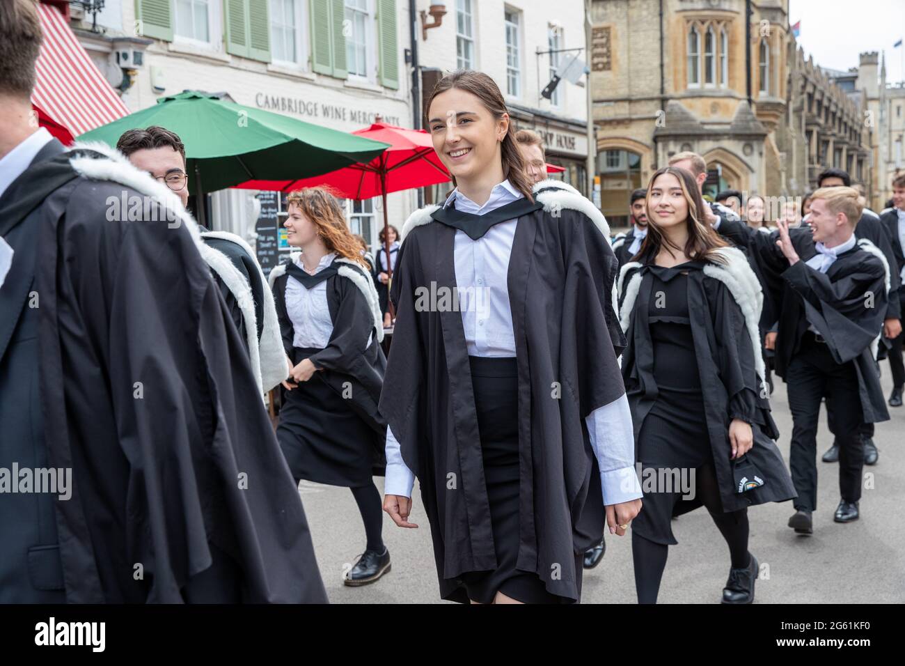 Picture dated  July 1st 2021 shows students from  Queens’  Cambridge on their graduation day which has returned after the ceremony was cancelled last year due to the Coronavirus pandemic.  Students dressed in black gowns as the traditional Cambridge University graduation ceremonies took place – after they were cancelled last year due to the Coronavirus pandemic. The students paraded into historic Senate House to collect their degrees from the prestigious university. Family and friends would normally watch the ceremony inside the Senate House, but this year they had to wait outside due to Covid Stock Photo