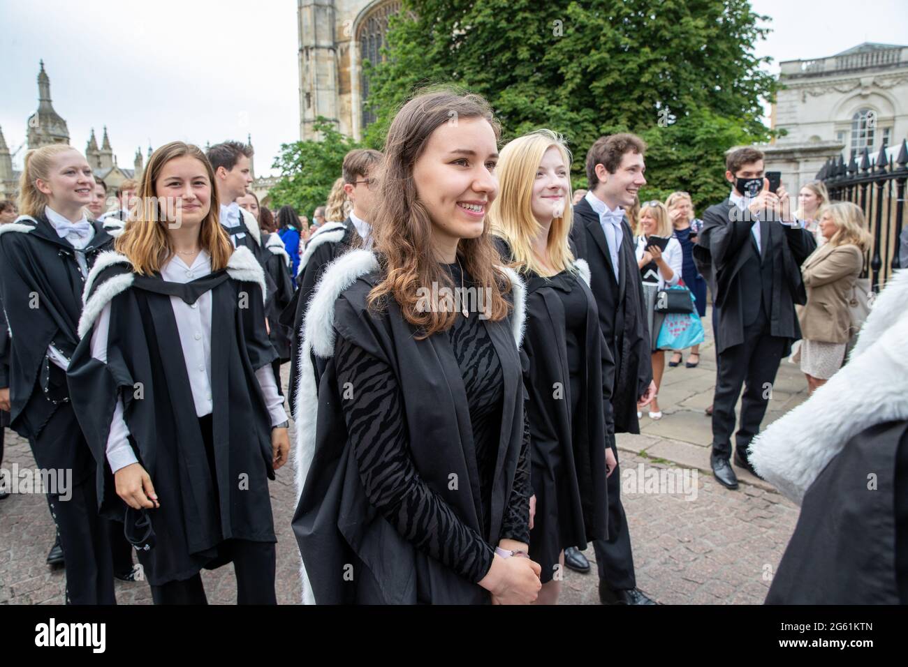 Picture dated  July 1st 2021 shows students from  Queens’  Cambridge on their graduation day which has returned after the ceremony was cancelled last year due to the Coronavirus pandemic.  Students dressed in black gowns as the traditional Cambridge University graduation ceremonies took place – after they were cancelled last year due to the Coronavirus pandemic. The students paraded into historic Senate House to collect their degrees from the prestigious university. Family and friends would normally watch the ceremony inside the Senate House, but this year they had to wait outside due to Covid Stock Photo