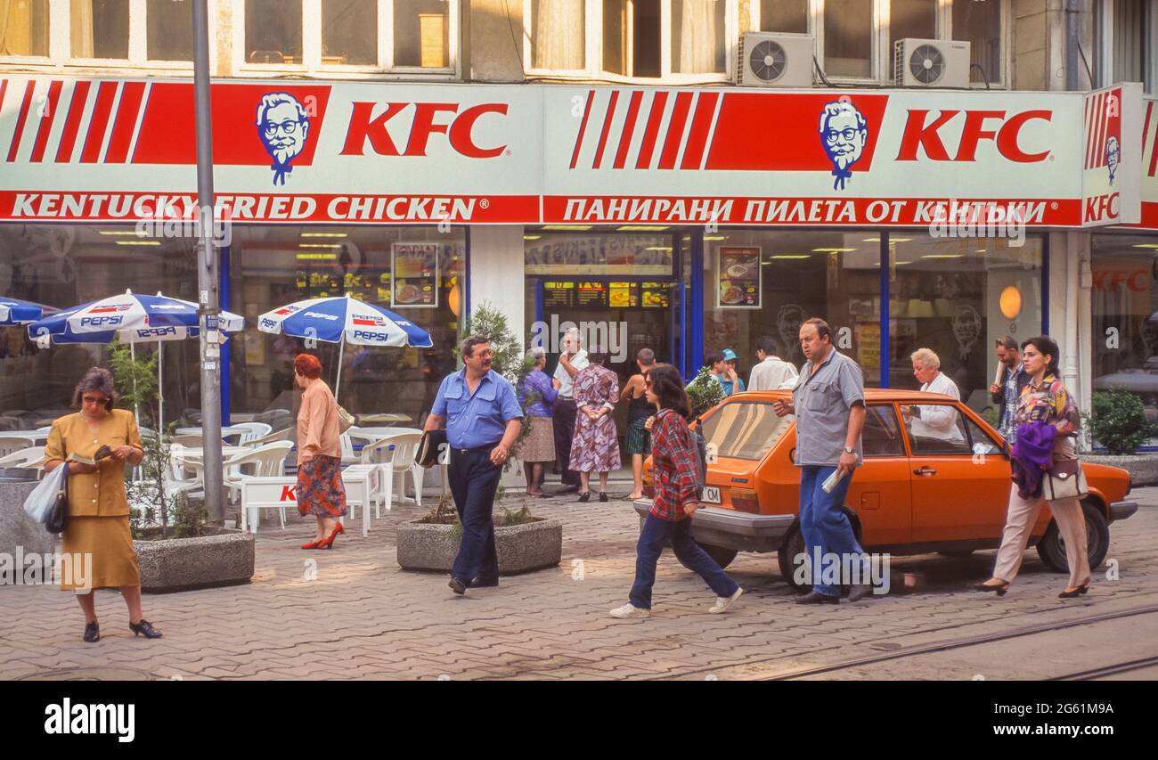 SOFIA, BULGARIA - People on sidewalk in front of KFC restaurant, Kentucky Fried Chicken fast food. Stock Photo