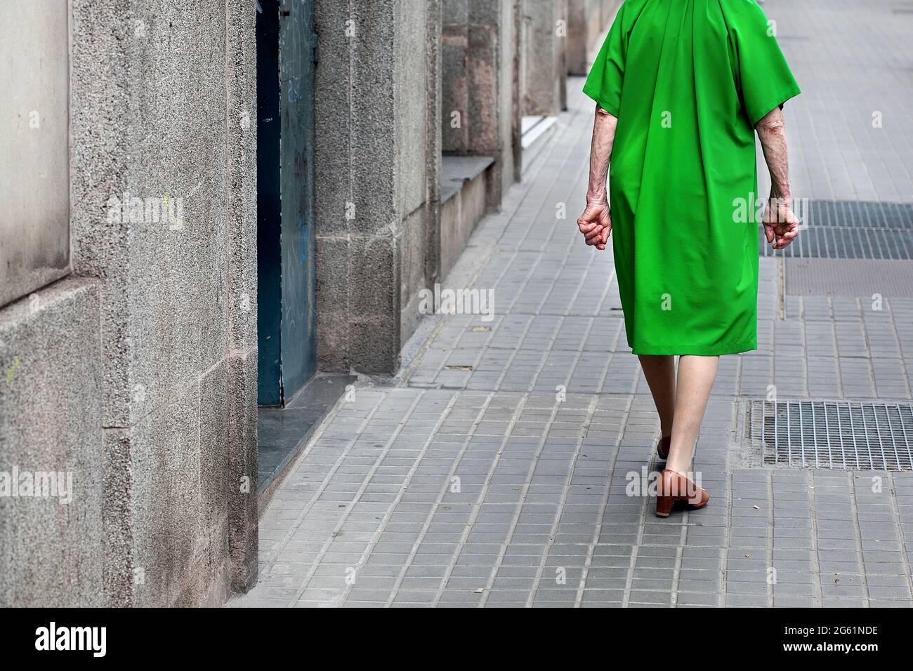 Old woman in apple green dress, Barcelona, Spain. Stock Photo
