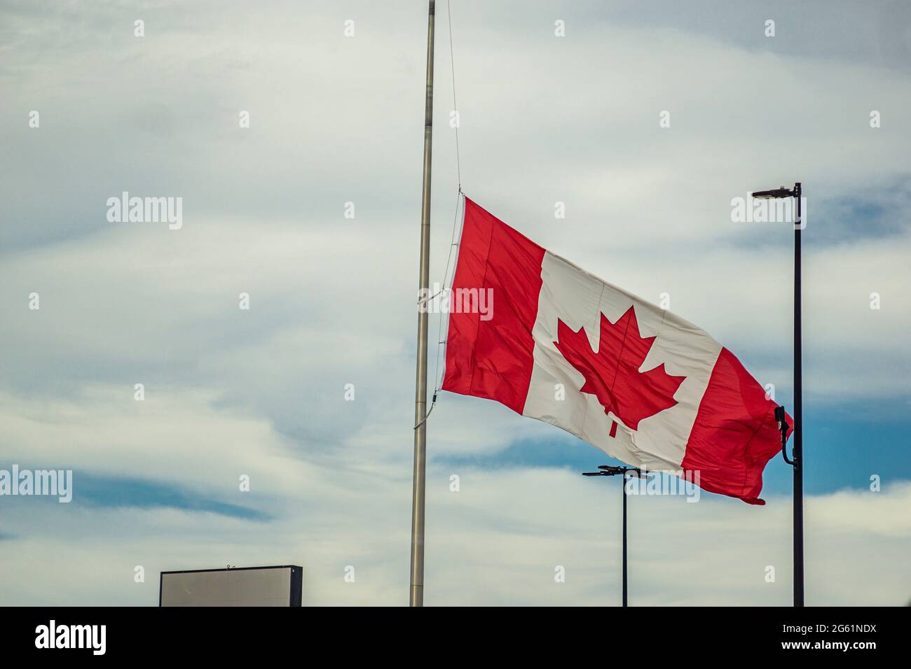 Canadian Flag flowing at half mast after the discovery of unmarked graves across three former residential schools site in Canada Stock Photo