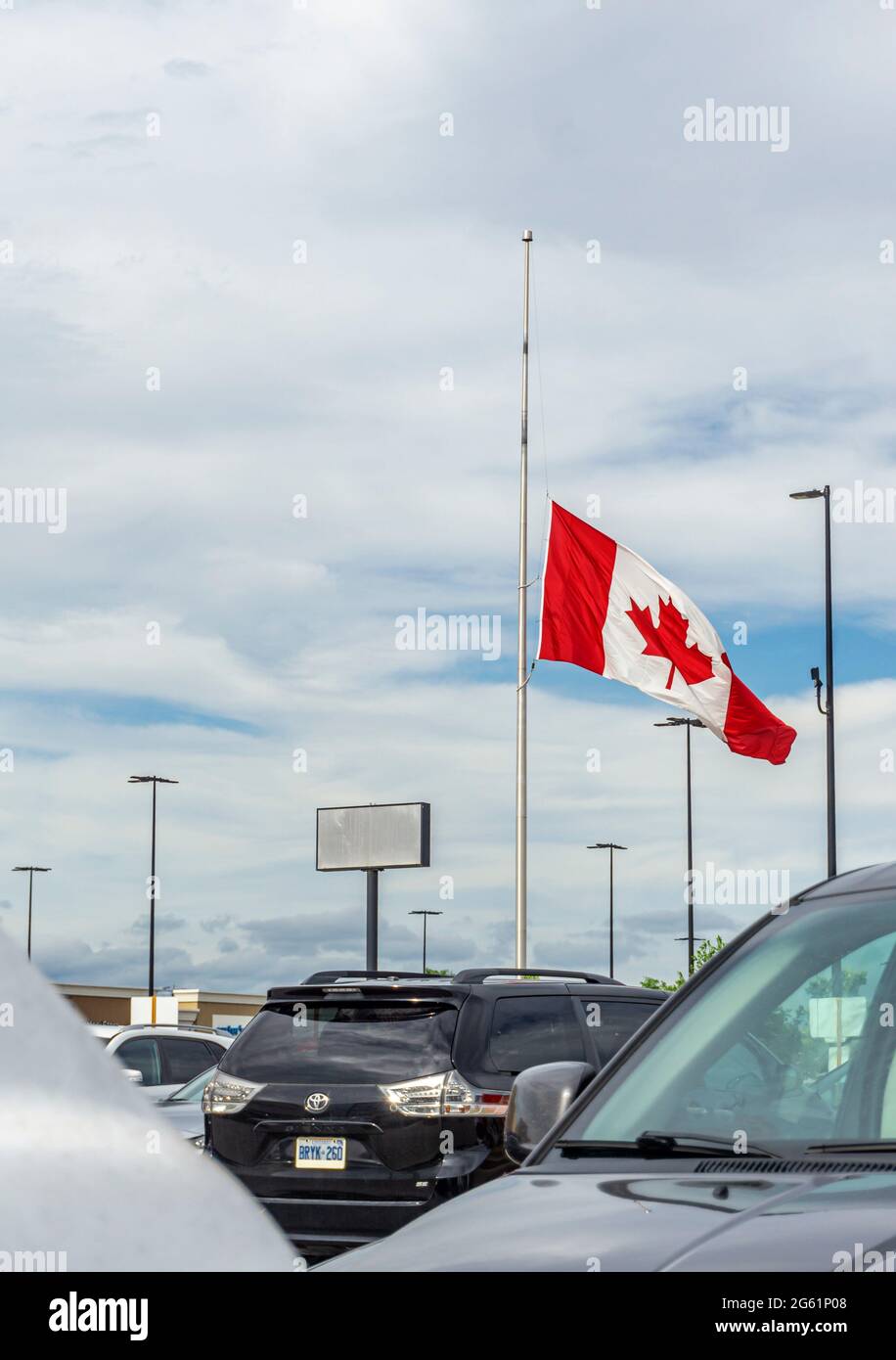 Toronto, June 2021 - Canadian Flag flowing at half mast after the discovery of unmarked graves across three former residential schools site in Canada Stock Photo