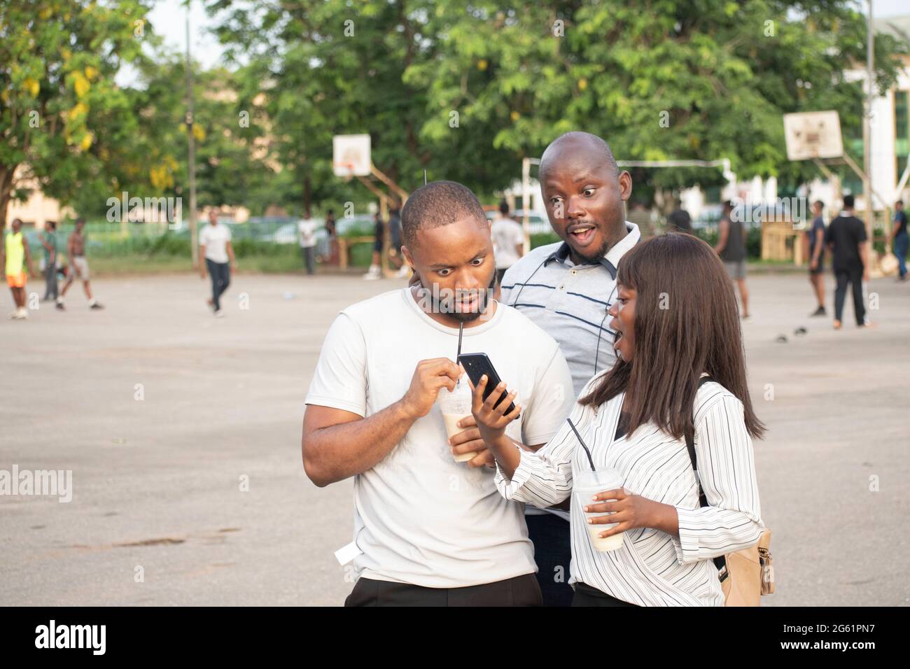 three young african people outdoor looking into their phone Stock Photo