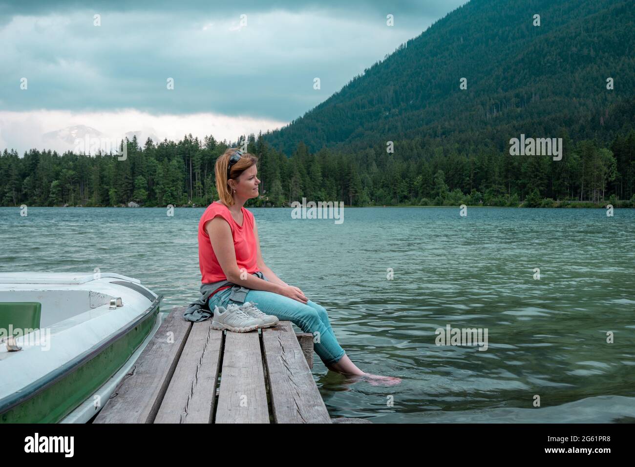 Young woman relaxing on pier at the lakeside Stock Photo