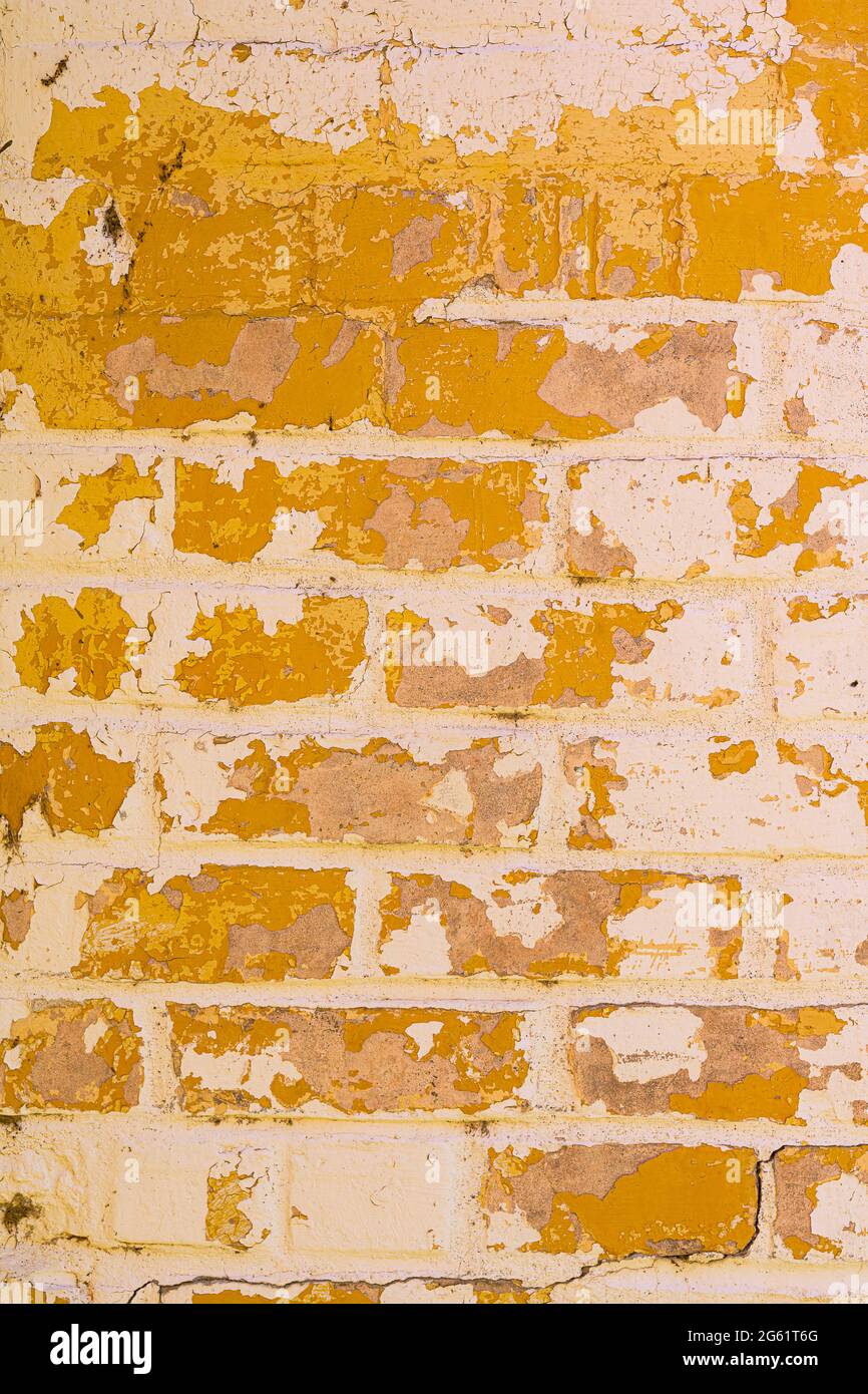 Yellow faded paint on white brick forms abstract background pattern Stock Photo