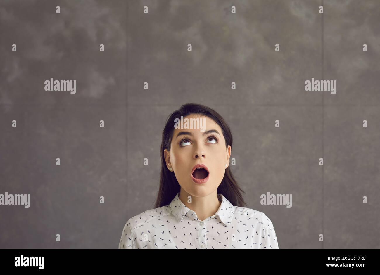 Young caucasian woman with opened mouth looking up feeling shock emotion Stock Photo