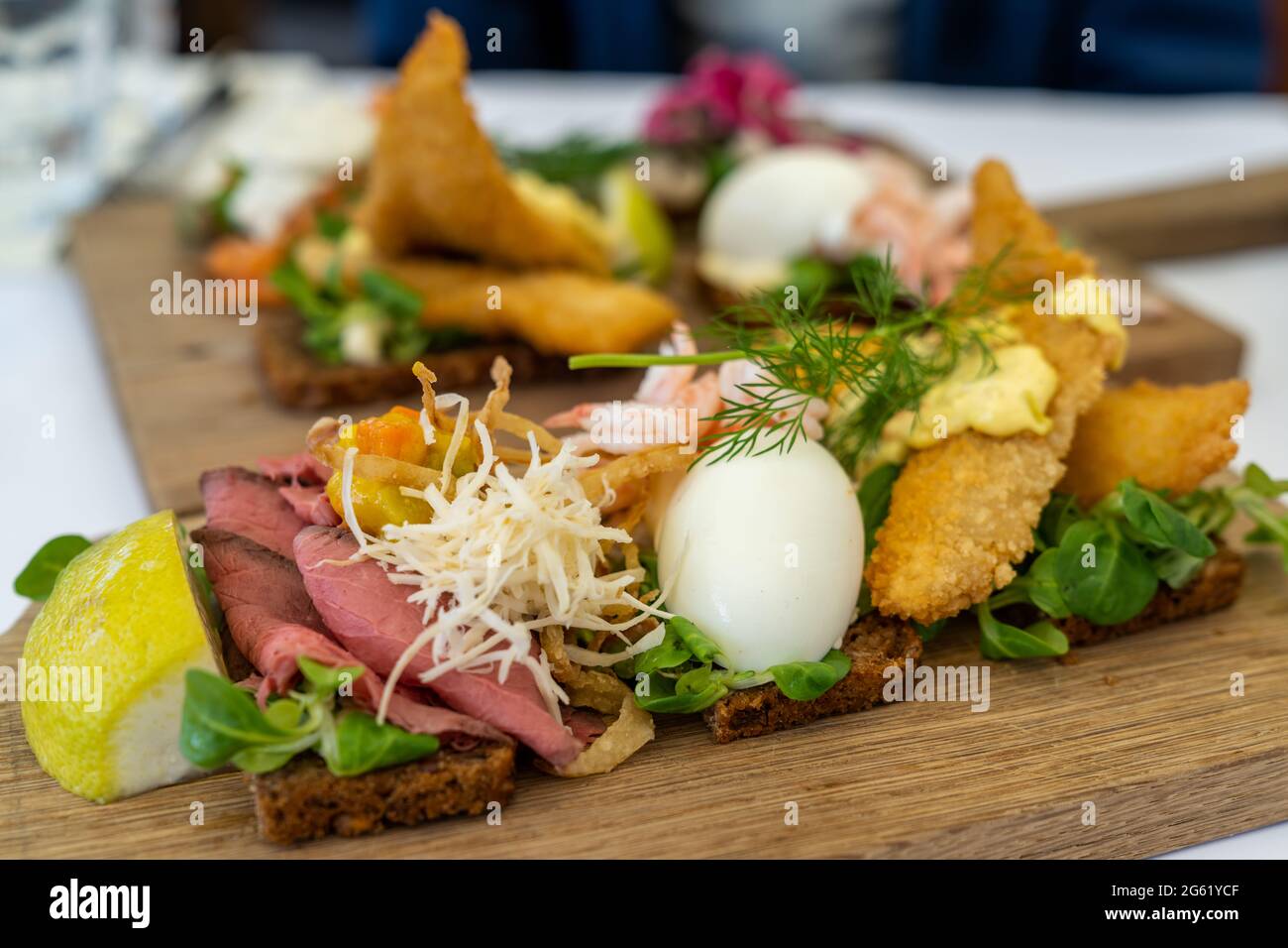 A close up view of delicious Smørebrød sandwiches on a wooden platter as a typical Scandinavian breakfast Stock Photo