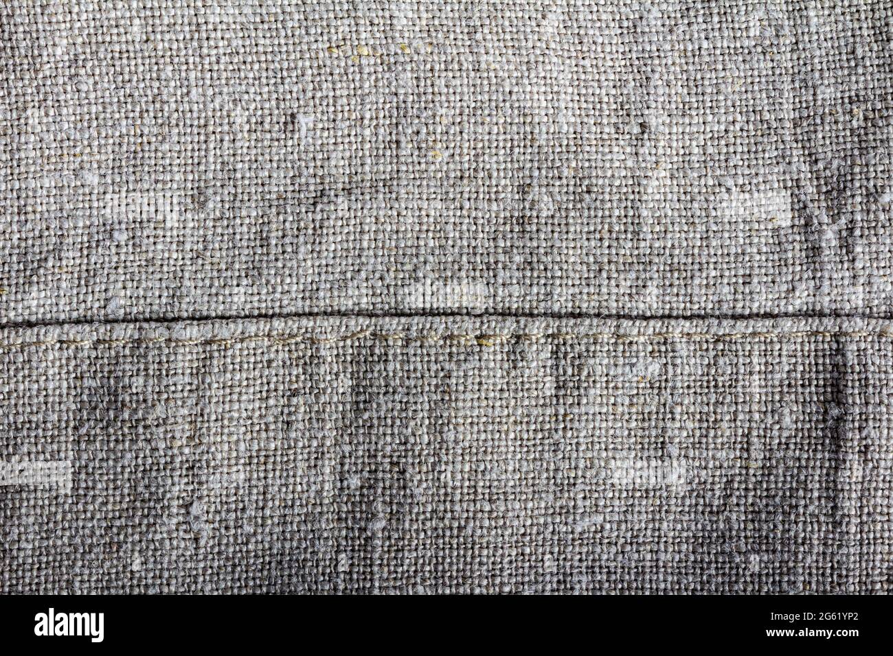 Close-up texture photo of grey colored linen cloth material with seam. Stock Photo