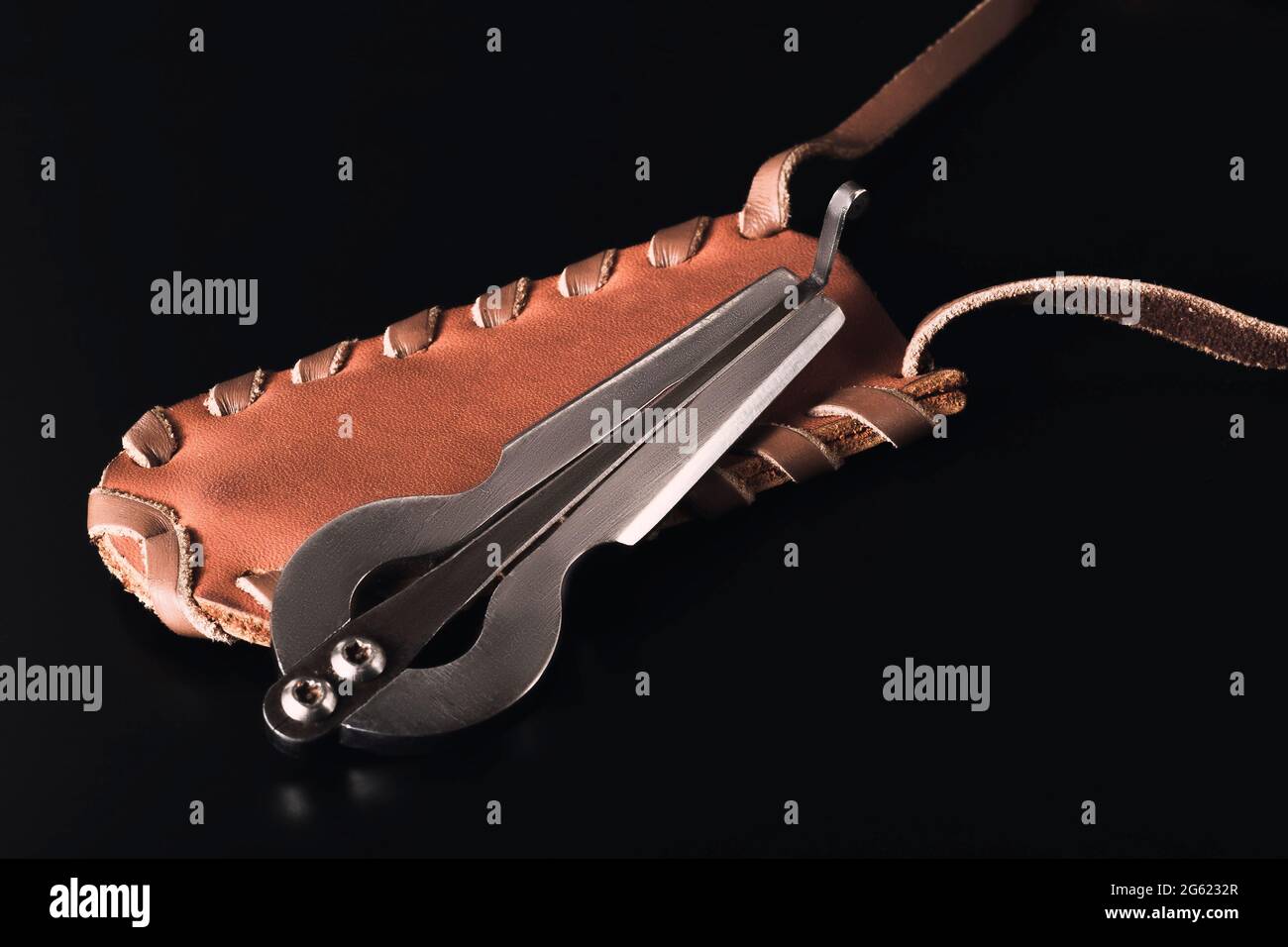 The harp compass lies on a leather case. Dark background. Stock Photo