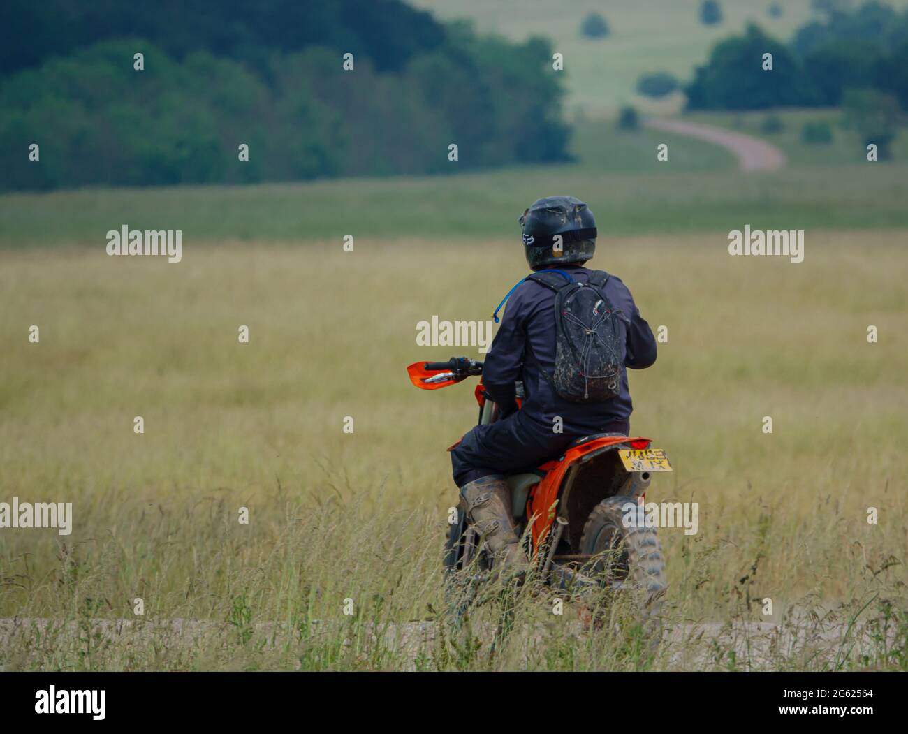 motor cyclist (biker) riding his motorbike along a stone track on Salisbury Plain, Wiltshire Stock Photo