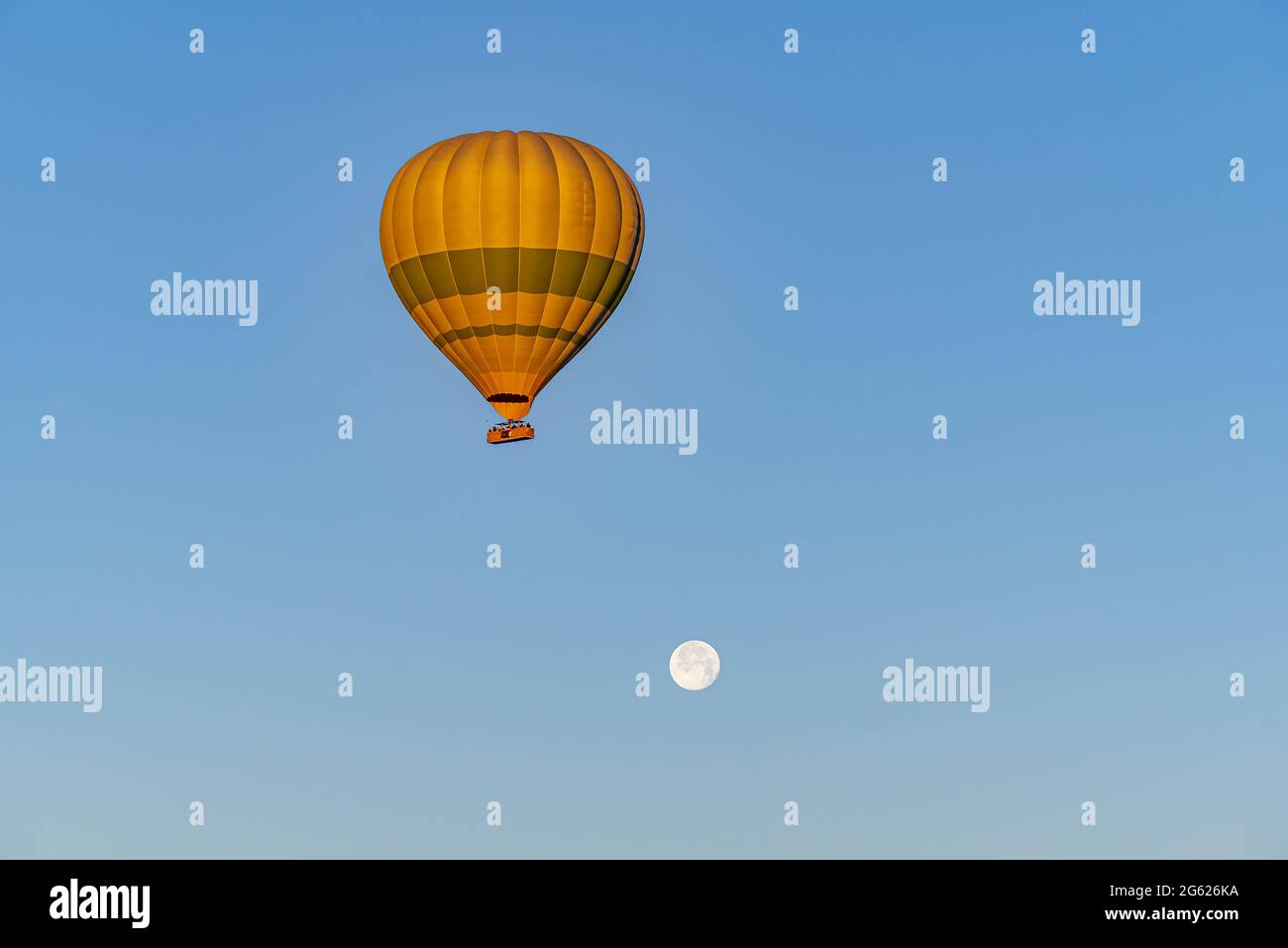 Shot of air balloon flying in blue sky with full moon Stock Photo - Alamy