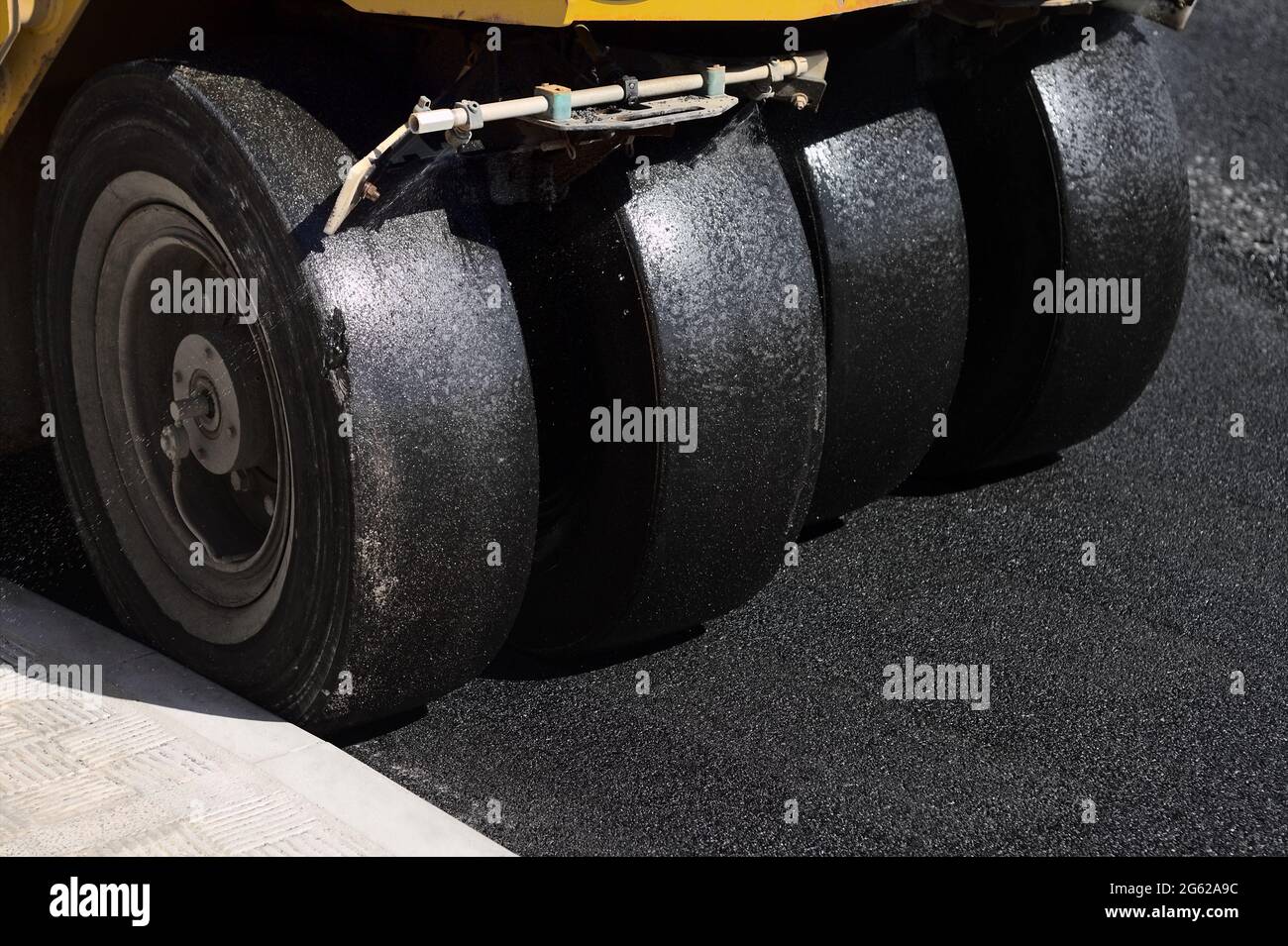 Multi-wheel rubber tyre roller compactor machine asphalting tar asphalt on road street construction Stock Photo