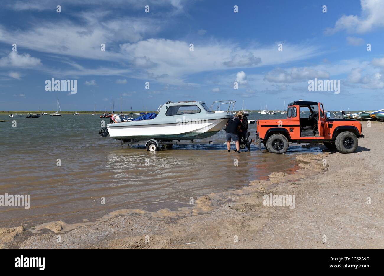 launching  boat at high tide brancaster staithe norfolk englandd Stock Photo